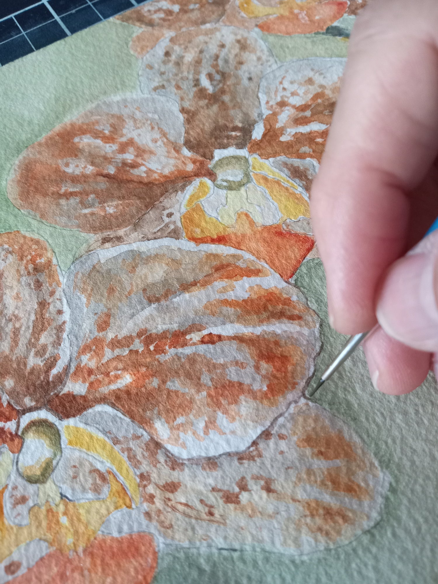 The artist painting fine detail on the middle orchid in Three Sisters, an original watercolor from the natureAWE collection by Silvana Varriale of VARsee art studio