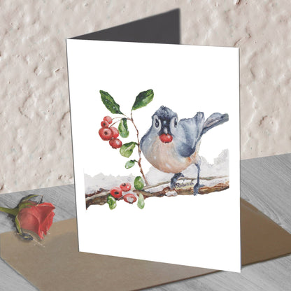Blue jay  bird watercolor greeting card standing on an envelope on a table, with a red rose beside.