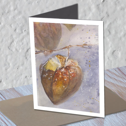 Chinese lantern watercolor greeting card standing on a kraft envelope.