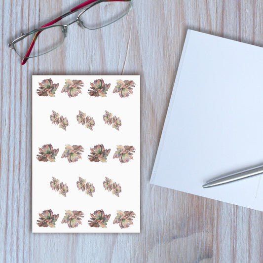 Hellebore design notebook closed, with another notebook open beside it, on wooden background.