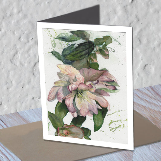 Hellebore watercolor greeting card standing on a kraft envelope.