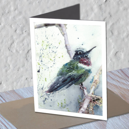 Hummingbird watercolor greeting card standing on a kraft envelope.