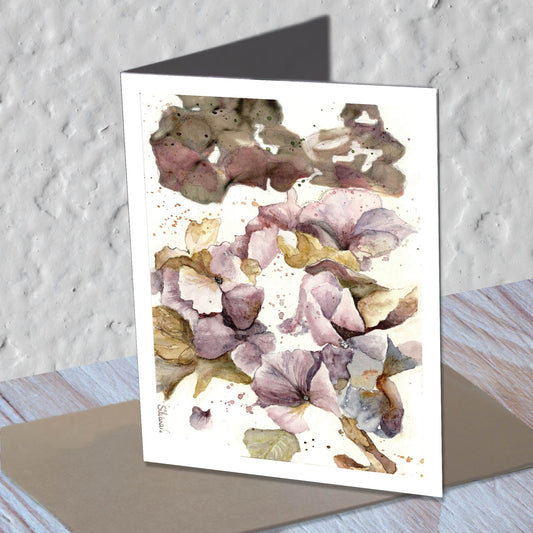 Hydrangea watercolor greeting card standing on a kraft envelope.