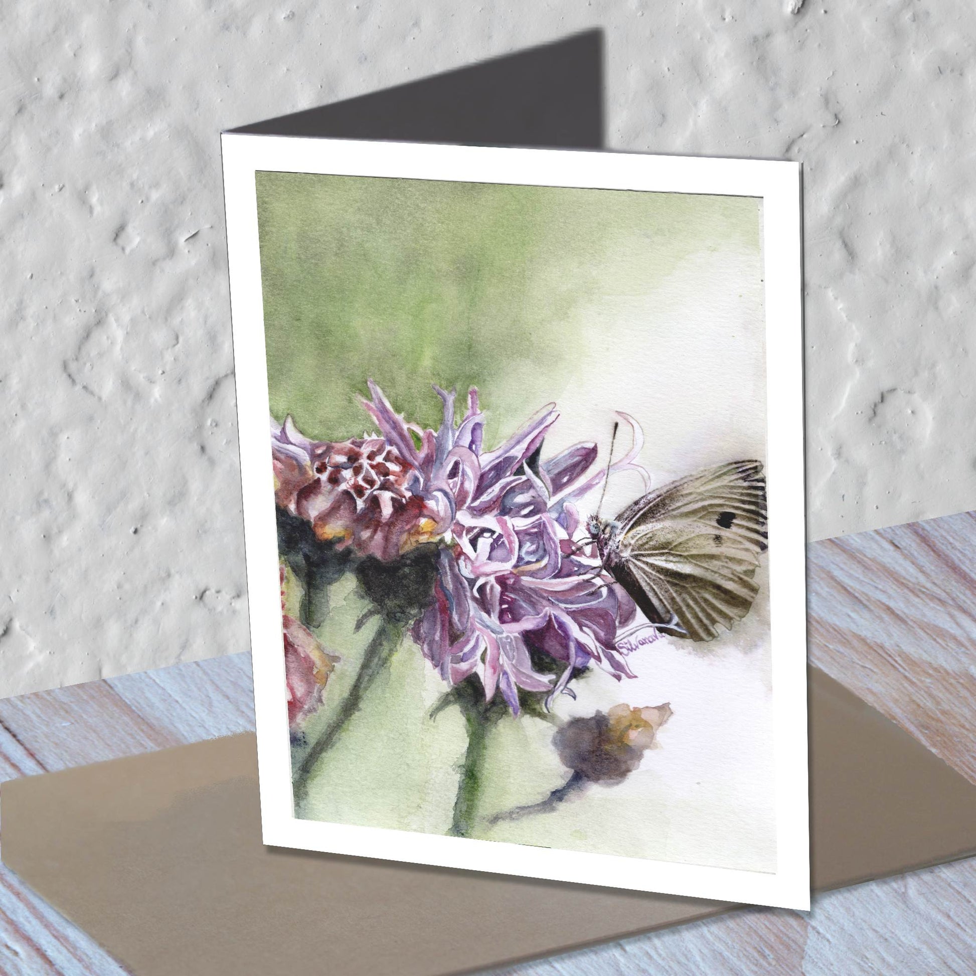 Knapweed watercolor greeting card standing on a kraft envelope.