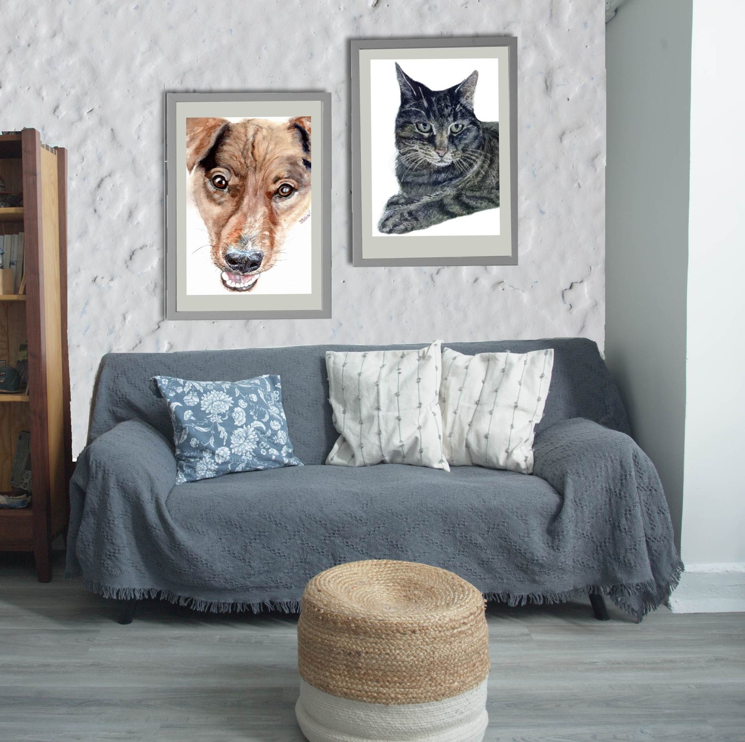 Gray blue sofa with decorative pillows, framed watercolors of a dog and a cat on the wall, and a woven stool.