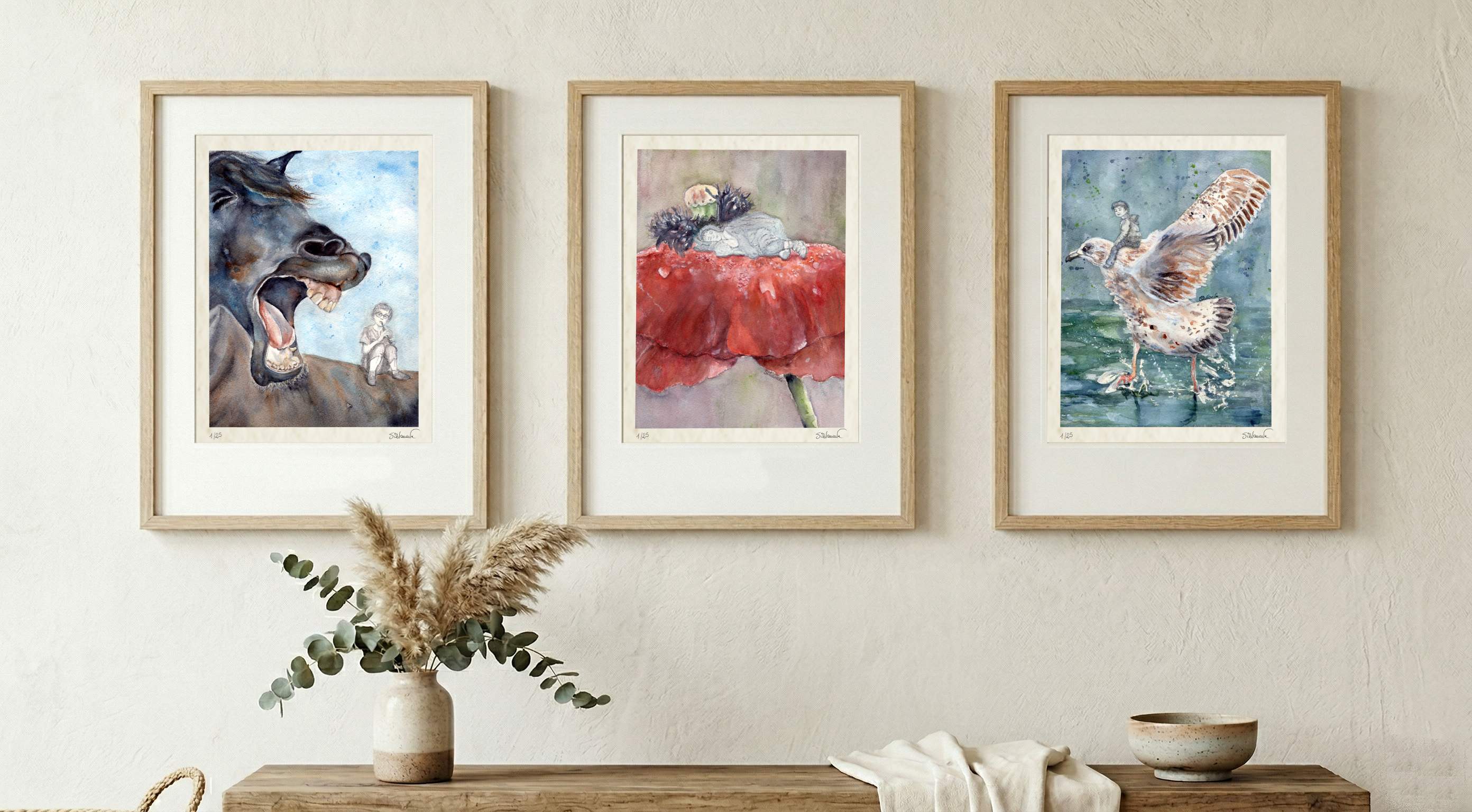 Giclée prints of "Horse voice", "Flowerbed" and "Wingspan Airlines" by Silvana Varriale of VARsee Art framed in wooden frames and displayed horizontally over a table with a bunch of greens, a white towel and a neutral tint bowl, rectangular image